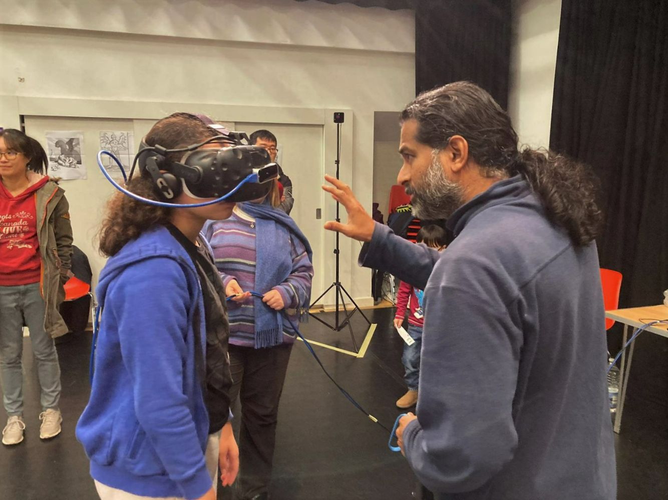 Researcher talking to a young person wearing a VR headset