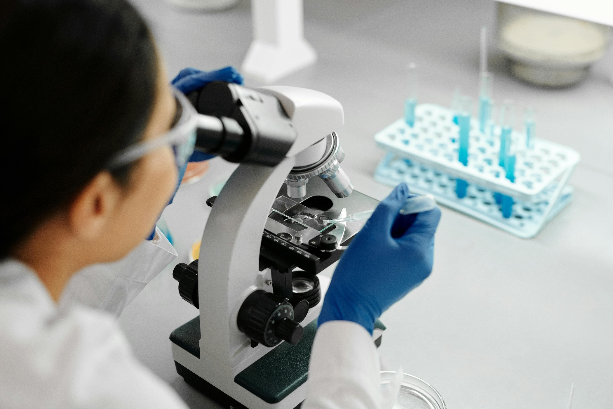 Scientist conducting research in a lab using a microscope and dropper