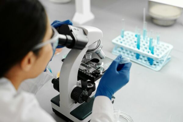 Scientist conducting research in a lab using a microscope and dropper